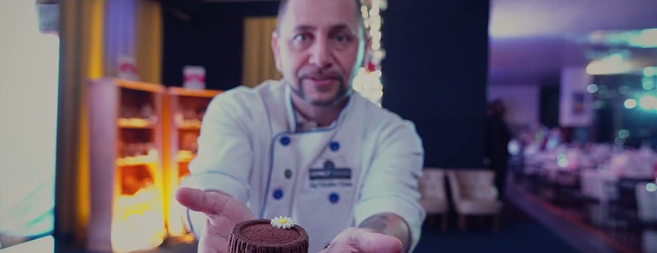 Chef mostrando um bolo pronto durante o evento da Diniz Foods